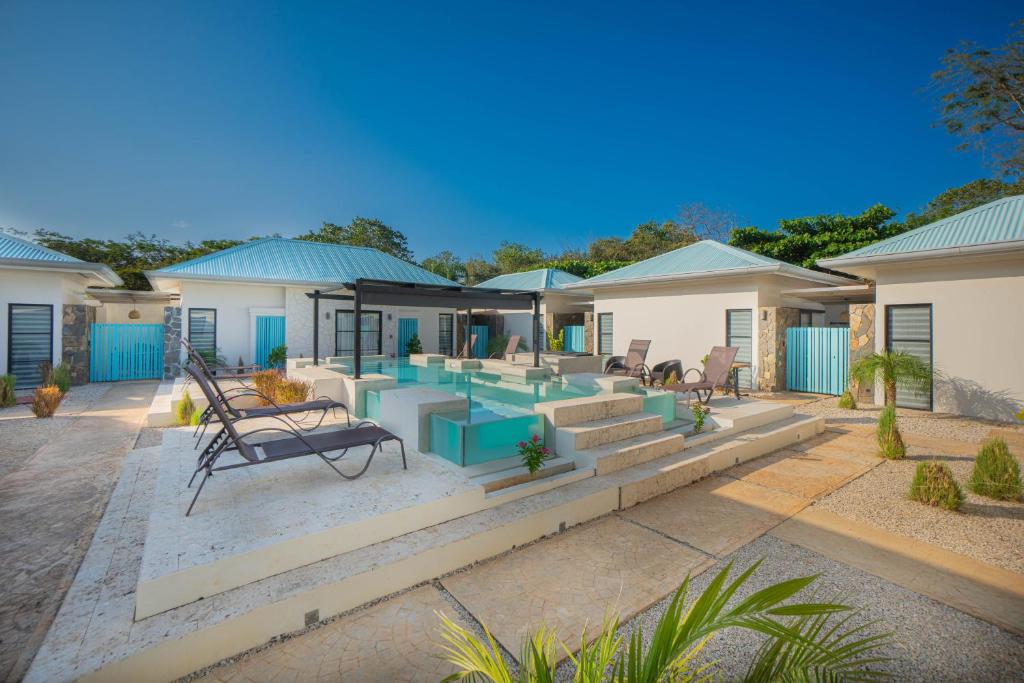 een huis met een zwembad en een patio bij Villas VR Beachwalk Avellanas in Playa Avellana