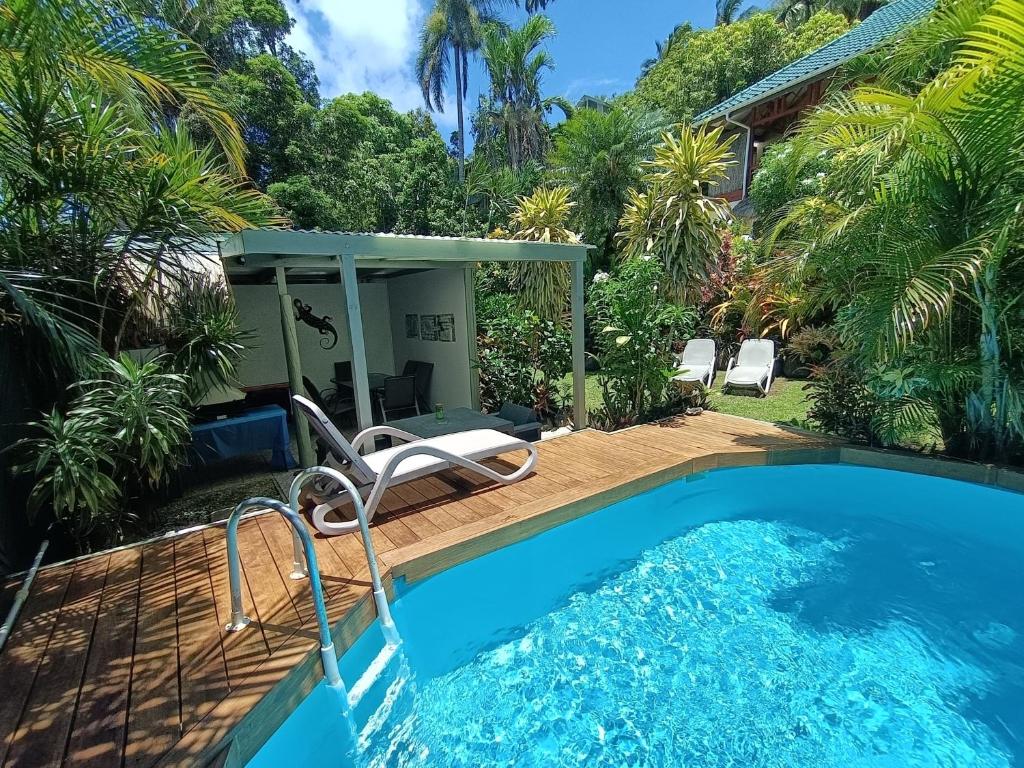 a pool with a chair next to a house at Muri Retreat Apartments in Rarotonga