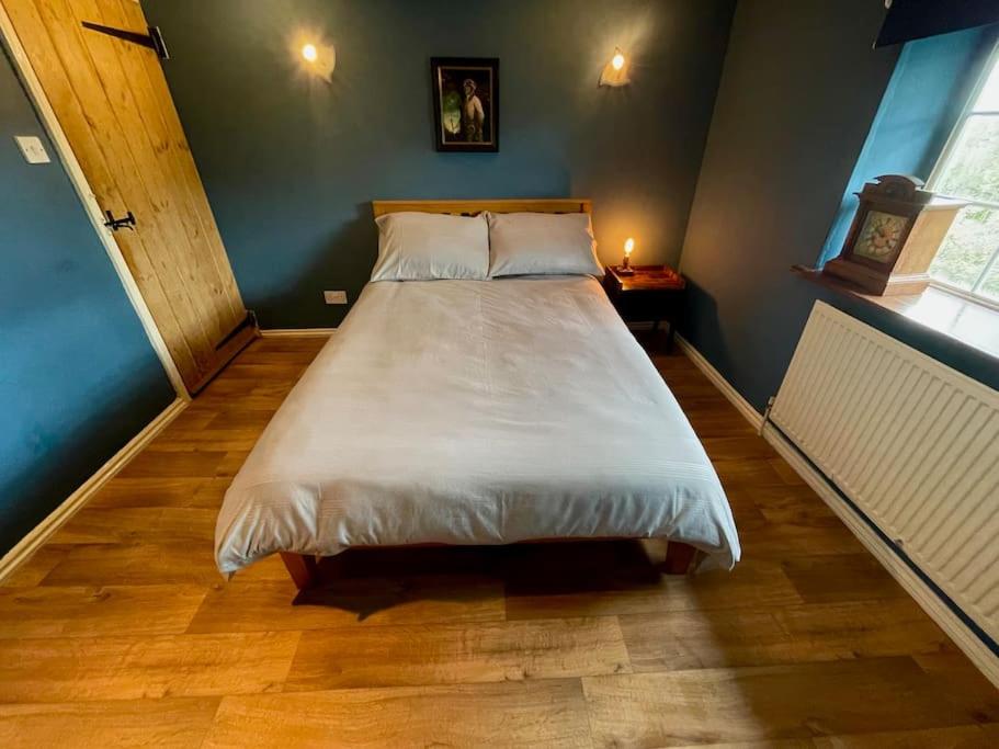 a bedroom with a large bed in a room at Rustic stone cottage with Hot Tub & fireplace in Crowborough