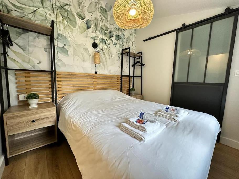 une chambre avec un lit avec deux serviettes dessus dans l'établissement Landouzy maison centre ville, à Reims