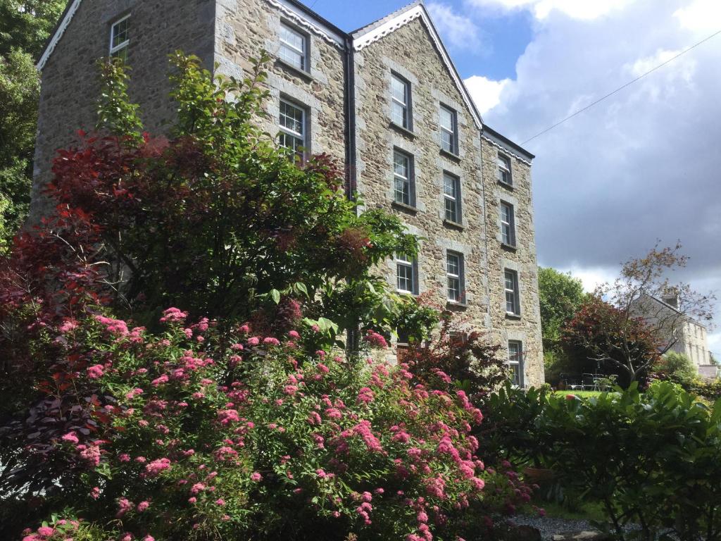 a large brick building with flowers in front of it at The Old Mill in Milford Haven