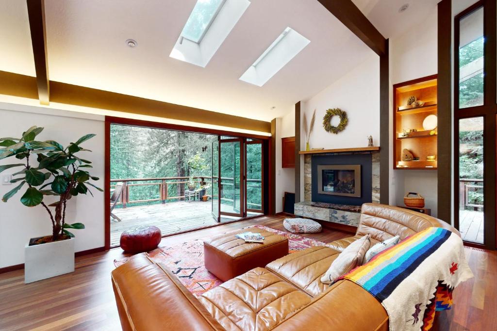 a living room with a leather couch and a fireplace at Mindful Forest Sanctuary in Mill Valley