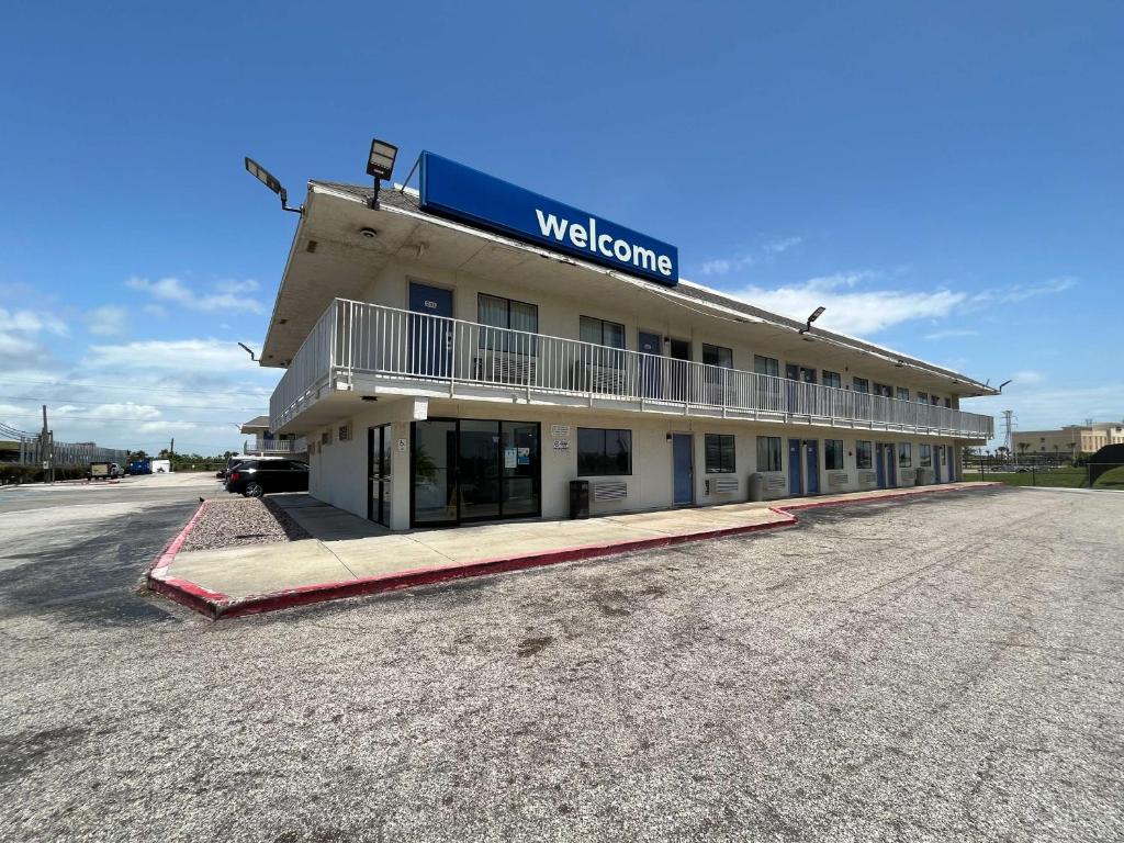 a building with a welcome sign on top of it at Studio 6 Galveston TX in Galveston