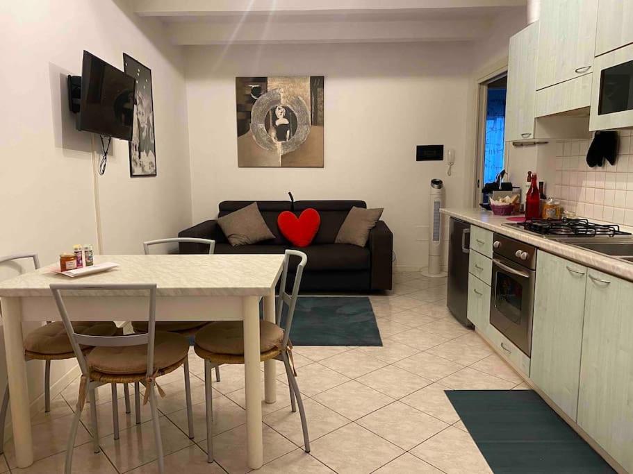 eine Küche und ein Wohnzimmer mit einem Tisch und einem Sofa in der Unterkunft Let It Be Franciacorta in Gussago