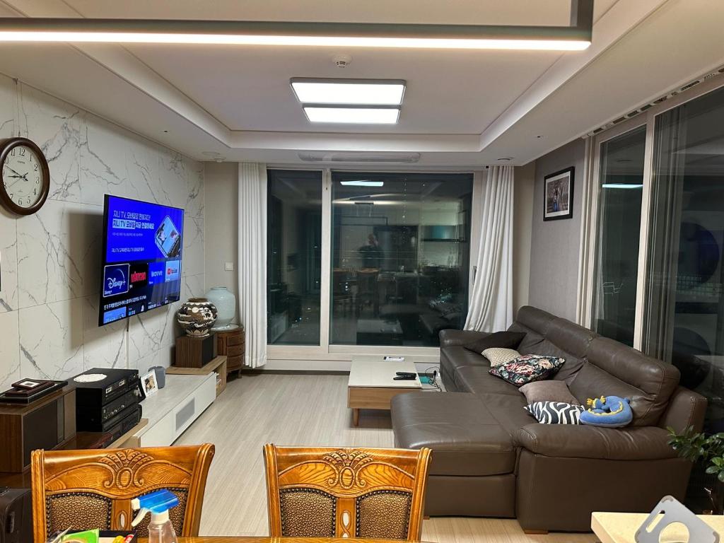 a living room with a couch and a tv at Byeollae Station ipark Suite in Namyangju