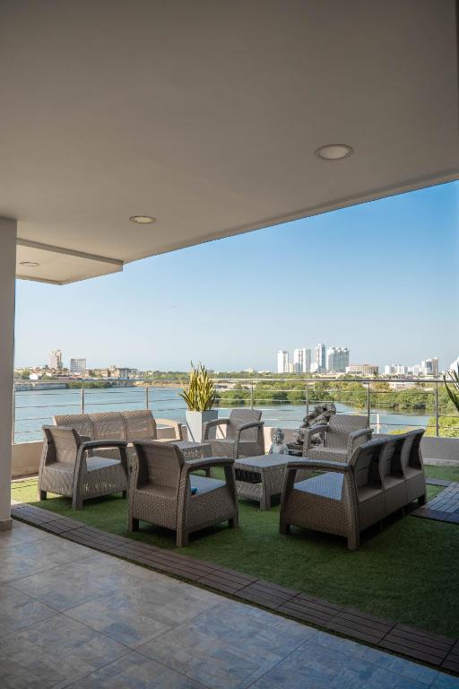 卡塔赫纳Bahia 79 Apartasuites Cerca al Centro的配有桌椅的露台，可欣赏水景