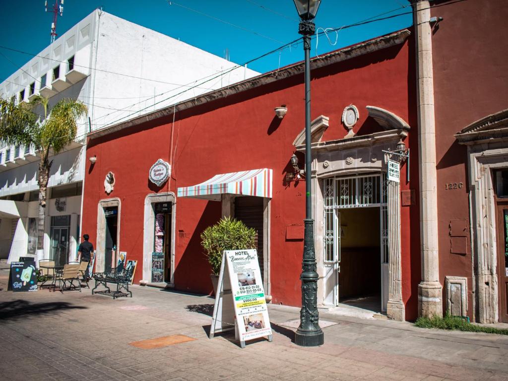 un edificio rojo con un cartel delante en Hotel Buenos Aires, en Durango