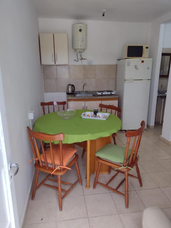 a small kitchen with a green table and chairs at Departamento in La Rioja