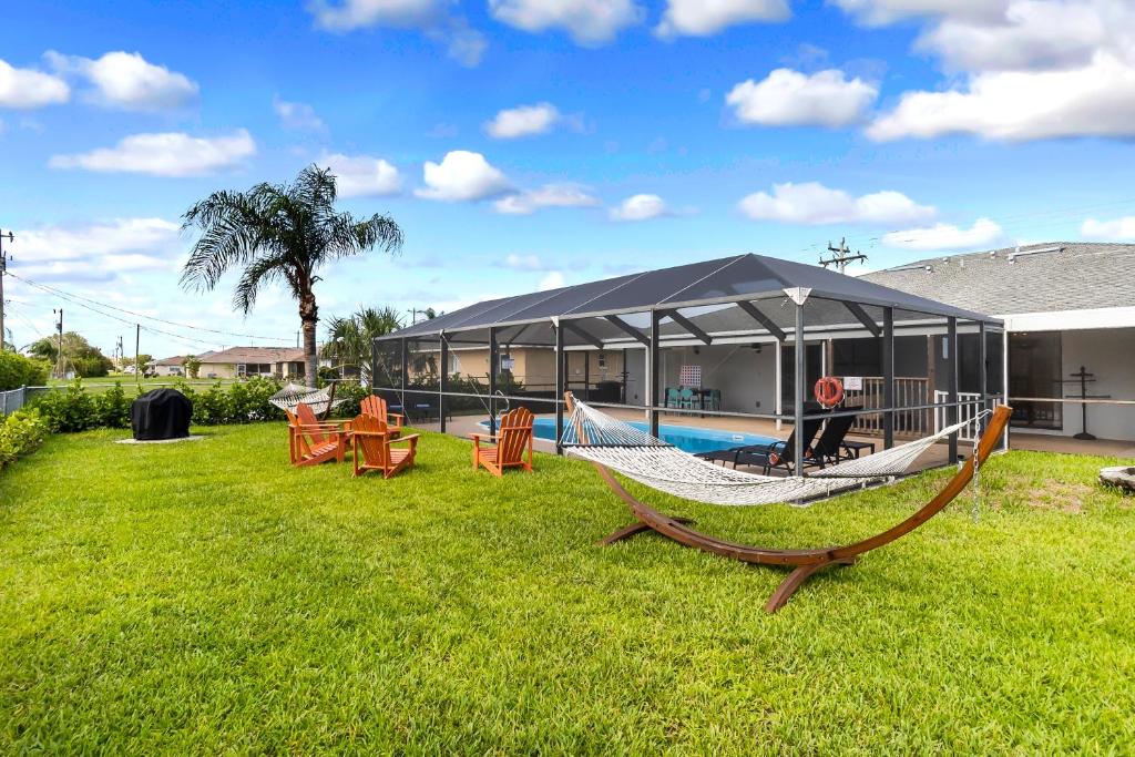 um quintal com uma rede de descanso e uma piscina em Casa Ocaso em Cape Coral