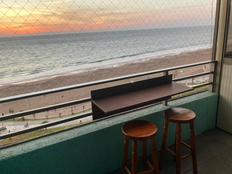 a view of the beach from a bar with two stools at Bella vista departamento amoblado in Iquique