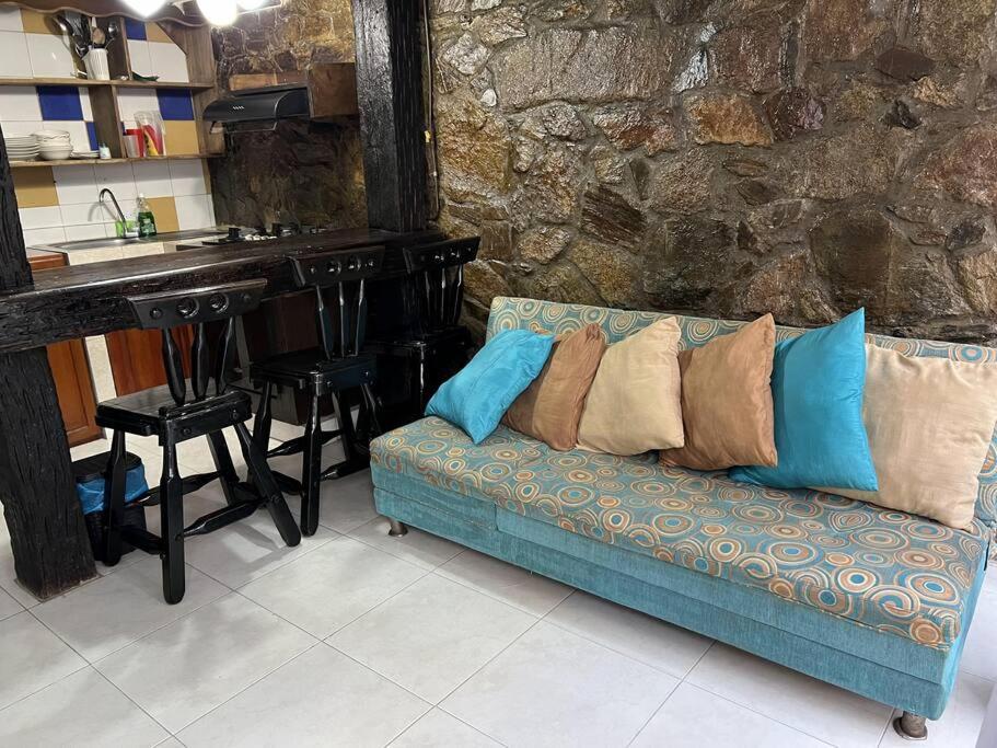 um sofá azul com almofadas numa cozinha com um balcão em Cabaña de descanso, Rodadero em Gaira