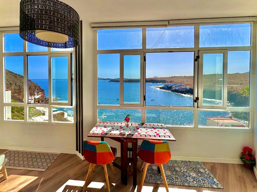 a dining room with a table with a view of the ocean at Beachfront - ocean view - sea view - modern - cozy - Netflix & Wi-Fi - islet view - dunes view - mountain view in Telde