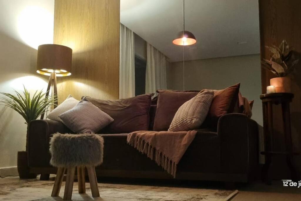 uma sala de estar com um sofá com almofadas em Apartment with 2 suites em Nova Lima