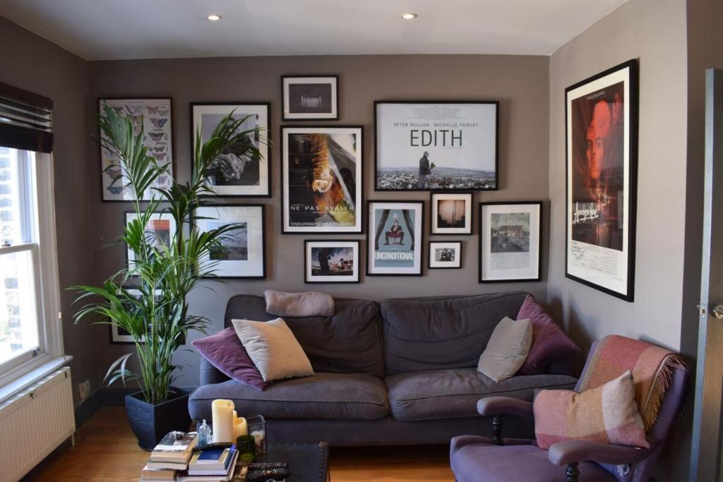 a living room with a couch and pictures on the wall at Contemporary 2BD Flat 4 Mins to Finsbury Park! in London