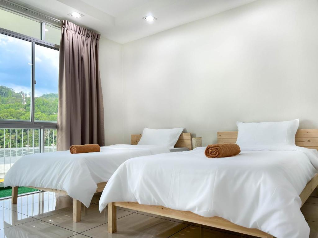 two beds in a room with a large window at Modern Muji Home Retreat near Taiping Lake Garden with Free Netflix in Taiping