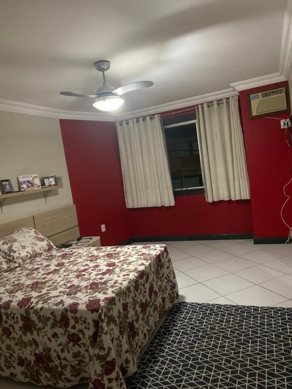 um quarto com uma cama e uma parede vermelha em Casa de ferias em Vitória