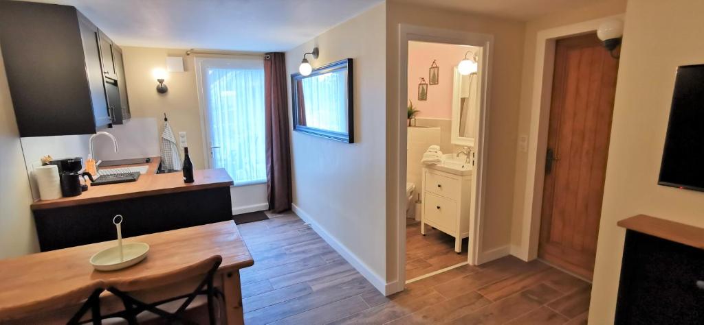 Il comprend une cuisine avec une table à manger et une salle de bains. dans l'établissement À mi-chemin, à Marcillac-Vallon