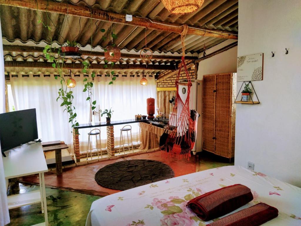 a bedroom with a bed and a guitar in a room at Chalé aconchegante, pertinho da cidade e conectada a natureza in Brasília