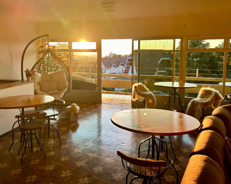 a room with tables and chairs and a couch at Hotel Casa Redonda Boutique Spa in Campos do Jordão