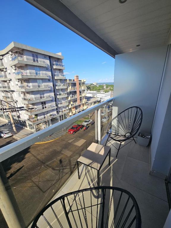 un balcon avec deux chaises et une vue sur une ville dans l'établissement Departamento zona residencial 2 Posadas Misiones, à Villa Dolores