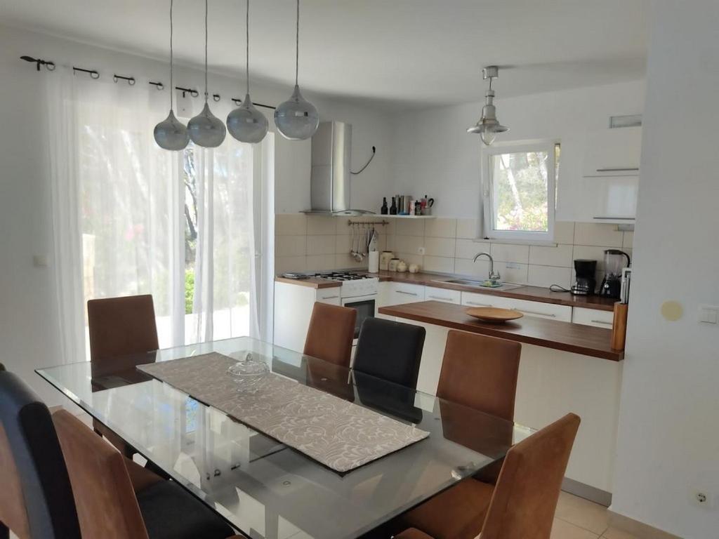 a kitchen with a glass table and chairs at Seaside holiday house Cove Tri luke, Korcula - 22092 in Vela Luka