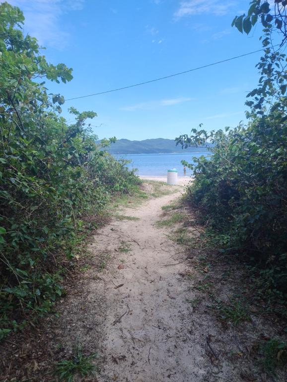 a dirt road leading to a beach with a trash can at Suite Daniela in Florianópolis