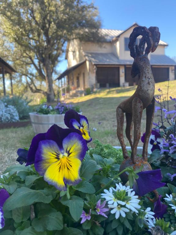 una estatua de una chica en un jardín de flores en V700 Ranch Stays (Guesthouse)-A Tucked Away Gem, en Marble Falls