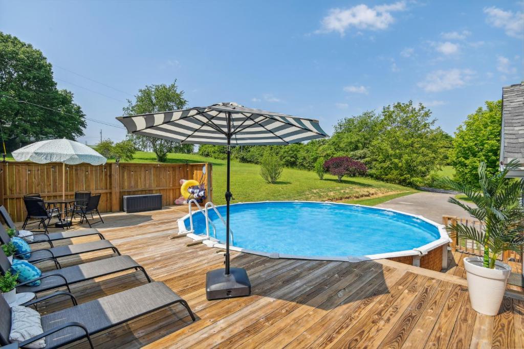 una piscina con sillas y una sombrilla en una terraza de madera en Peaceful White Bluff Vacation Rental with Pool!, en White Bluff