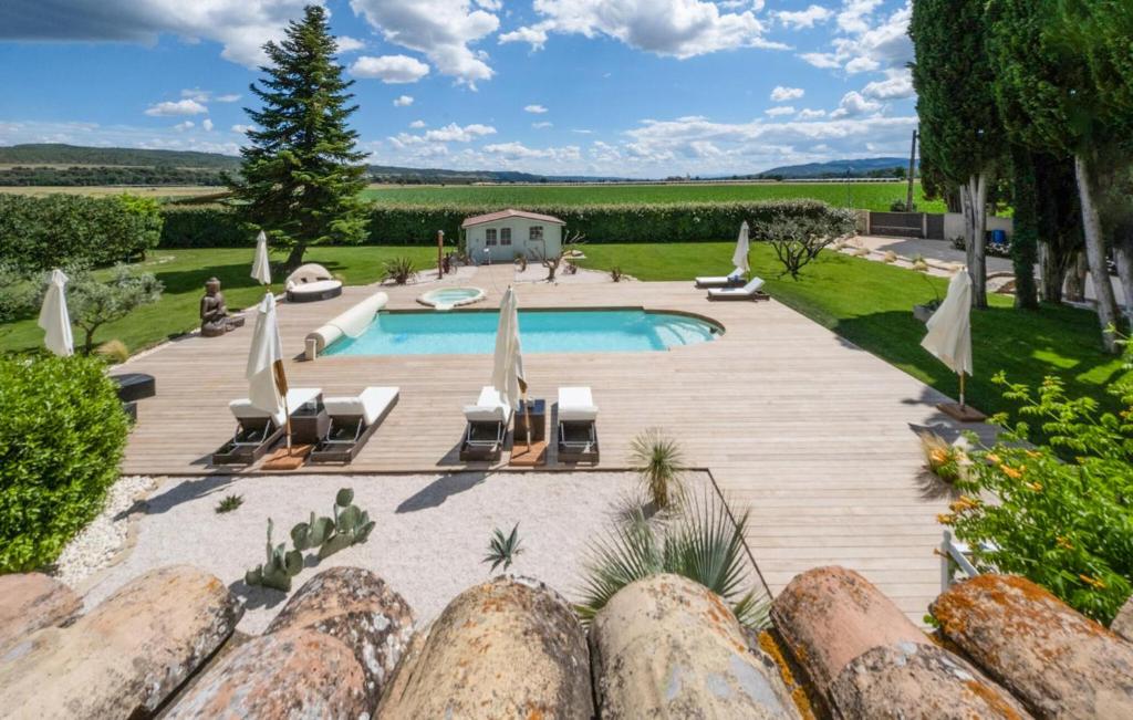 einen Hinterhof mit einem Pool und einer Holzterrasse in der Unterkunft Beautiful Home In Les Mes With Outdoor Swimming Pool in Les Mées