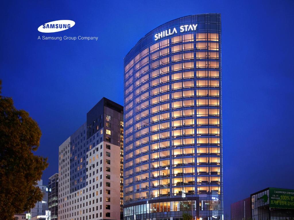 un edificio alto con un cartel de Sila Sky en él en Shilla Stay Ulsan, en Ulsan