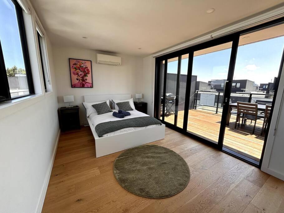 a bedroom with a bed and a view of a balcony at Four-Bedroom Town House in Port Melbourne in Melbourne