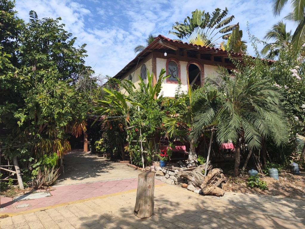 a house with palm trees in front of it at Posada Piedra de Fuego in Zipolite