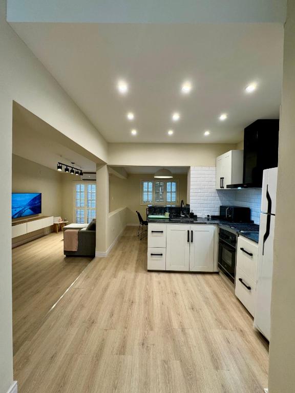 奇莱西托Casa Del Cable Carril的一间大厨房、白色橱柜和一间客厅