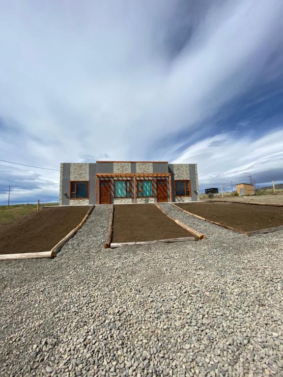 埃爾卡拉法特的住宿－Jardines del Calafate，一座带砾石的田野顶部的建筑