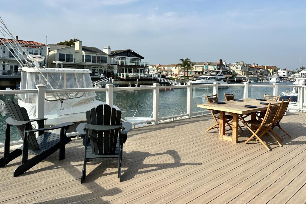 een houten terras met een tafel en stoelen en een boot bij Harbor Living in Oxnard