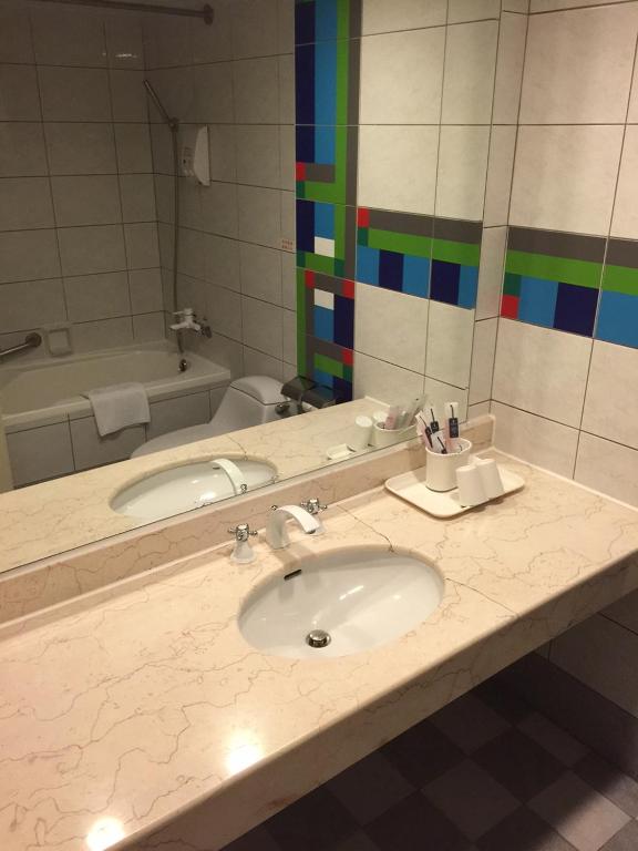 a bathroom counter with a sink and a mirror at King&#39;s Resort &amp; Spa in Tai&#39;an