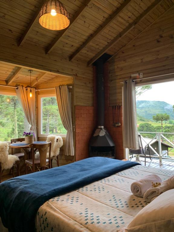 a bedroom with a bed and a table and a fireplace at Estalagem Villa Serrana in Urubici