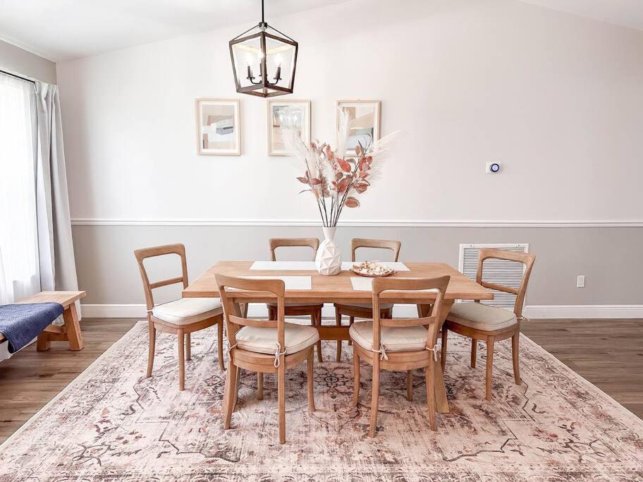 a dining room table with chairs and a vase with flowers at Great Location, 10 Mins to Beach, Vero Pool House in Vero Beach