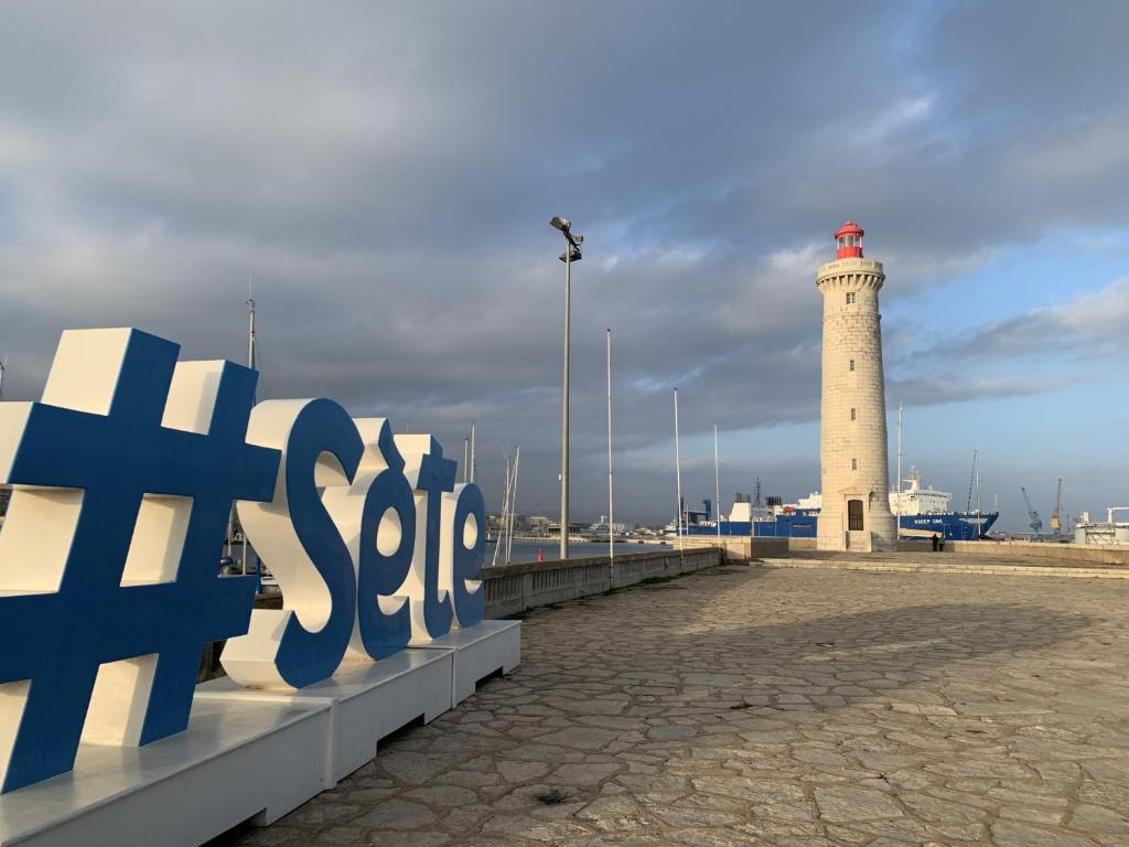 a lighthouse on a pier next to a lighthouse at Studio Sète, 1 pièce, 4 personnes - FR-1-338-406 in Sète