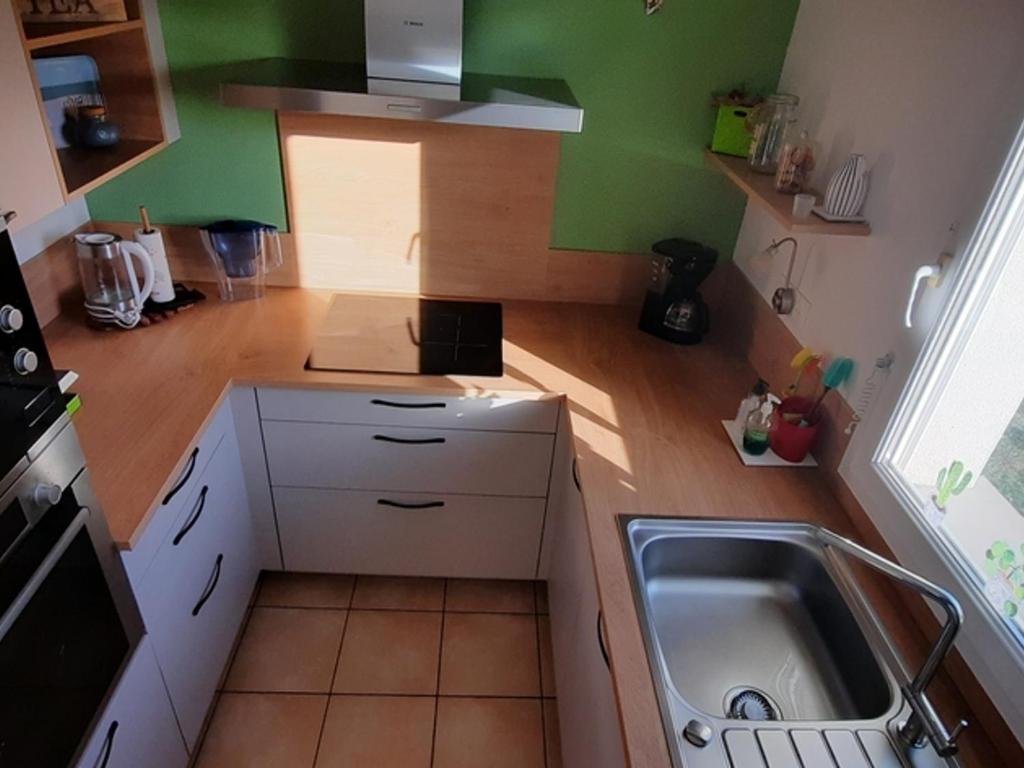 a small kitchen with white cabinets and a sink at Maison Le Tour-du-Parc, 4 pièces, 6 personnes - FR-1-639-51 in Le Tour-du-Parc