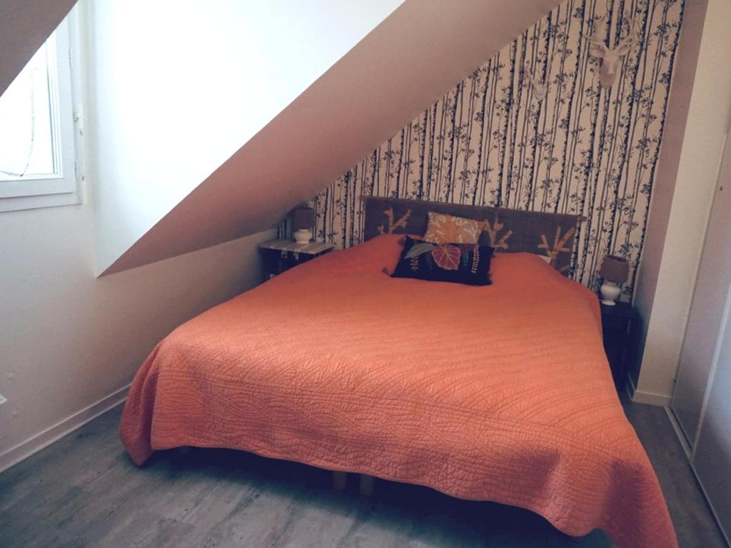 a bedroom with a bed with an orange blanket at Maison Le Tour-du-Parc, 4 pièces, 6 personnes - FR-1-639-51 in Le Tour-du-Parc