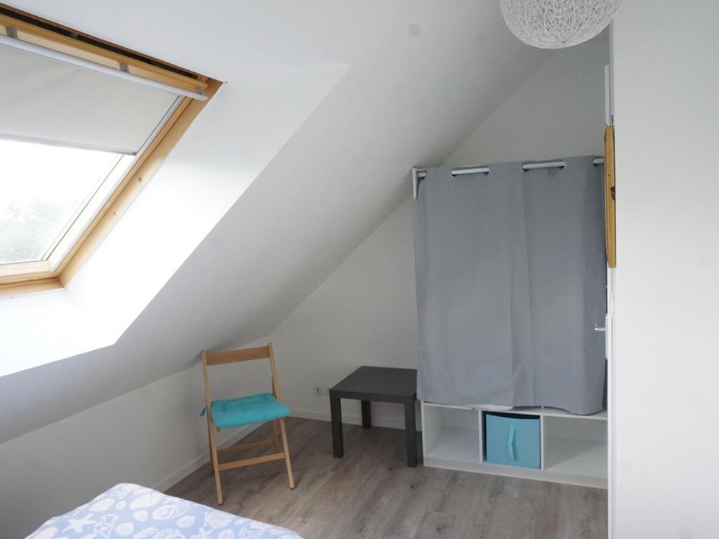 a attic bedroom with a bed and a chair at Maison Le Tour-du-Parc, 4 pièces, 6 personnes - FR-1-639-51 in Le Tour-du-Parc