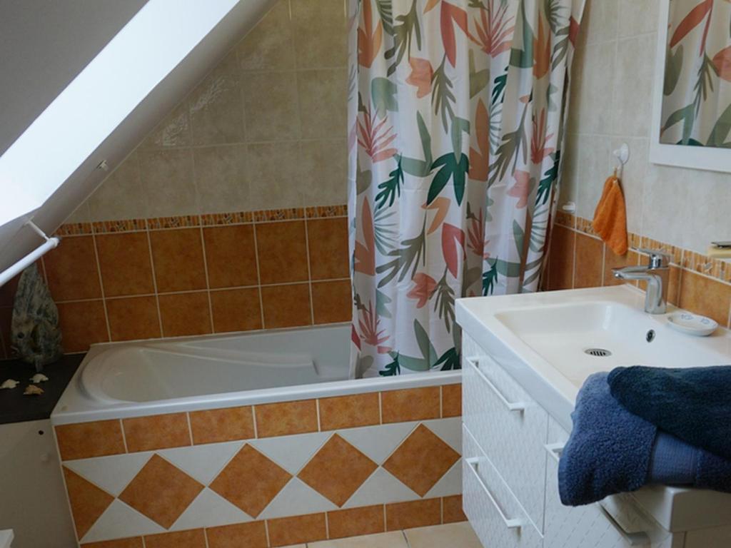 a bathroom with a bath tub and a sink at Maison Le Tour-du-Parc, 4 pièces, 6 personnes - FR-1-639-51 in Le Tour-du-Parc