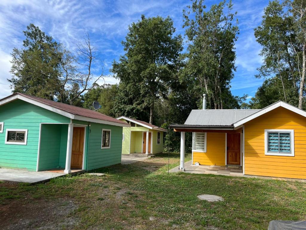 a row of colorful houses in a yard at Cabañas en Valdivia in Valdivia