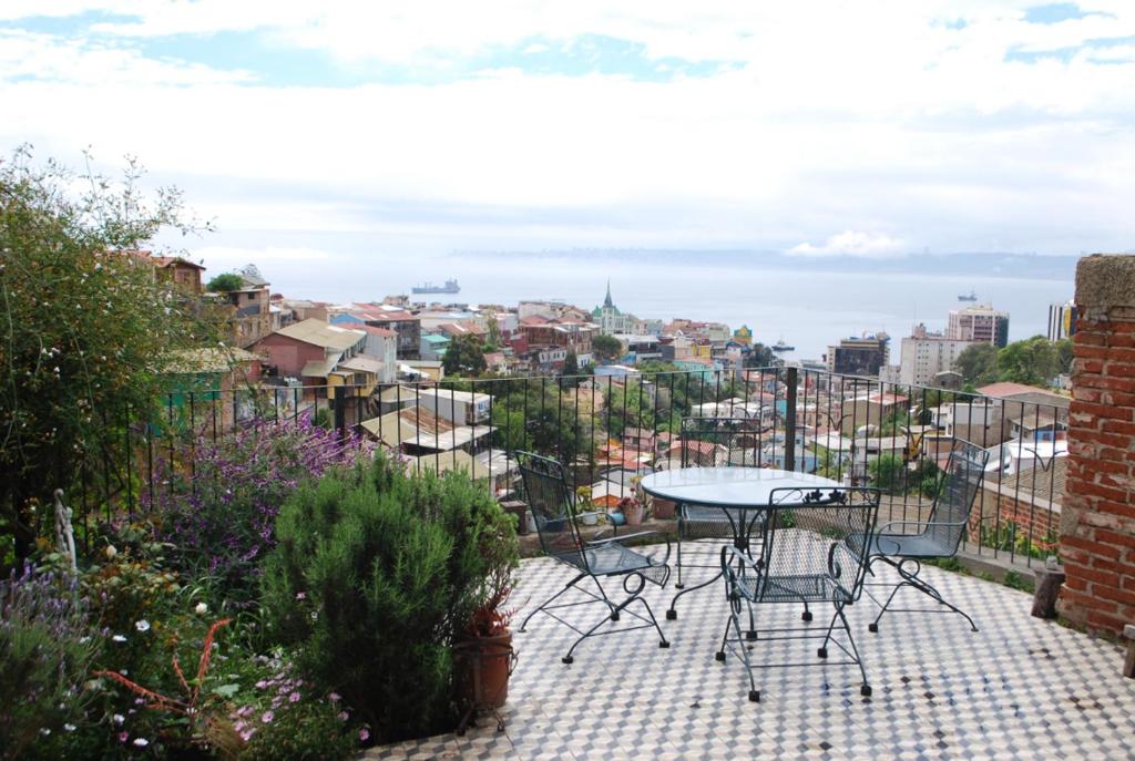 a patio with a table and chairs on a balcony at Casa Verde in Valparaíso