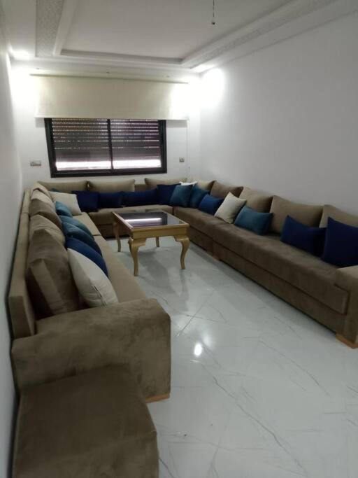 a living room with a couch and a table at Family Vacation Apartment- VacayX- Temara in Temara