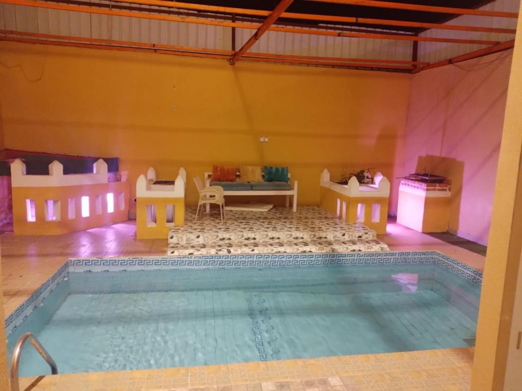 una camera con piscina, tavolo e sedie di شاليه للايجار الدرب ١ a Qarār