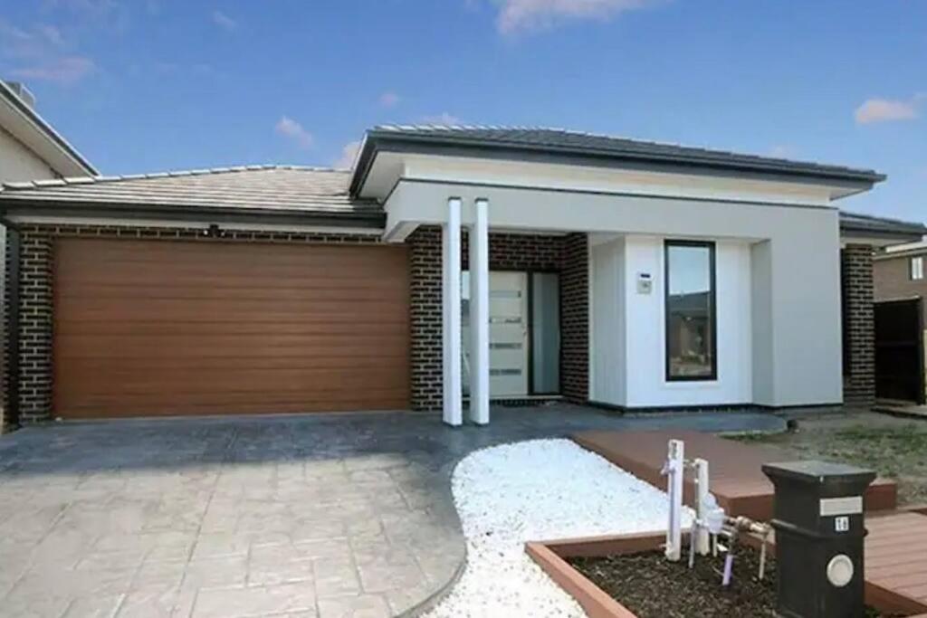 a house with a wooden garage door at Mel south east huge luxury home in Keysborough