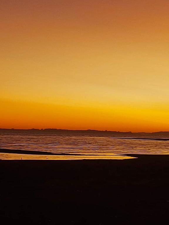 een zonsondergang op een strand met de oceaan bij Cabañas piedra azul in Puerto Montt