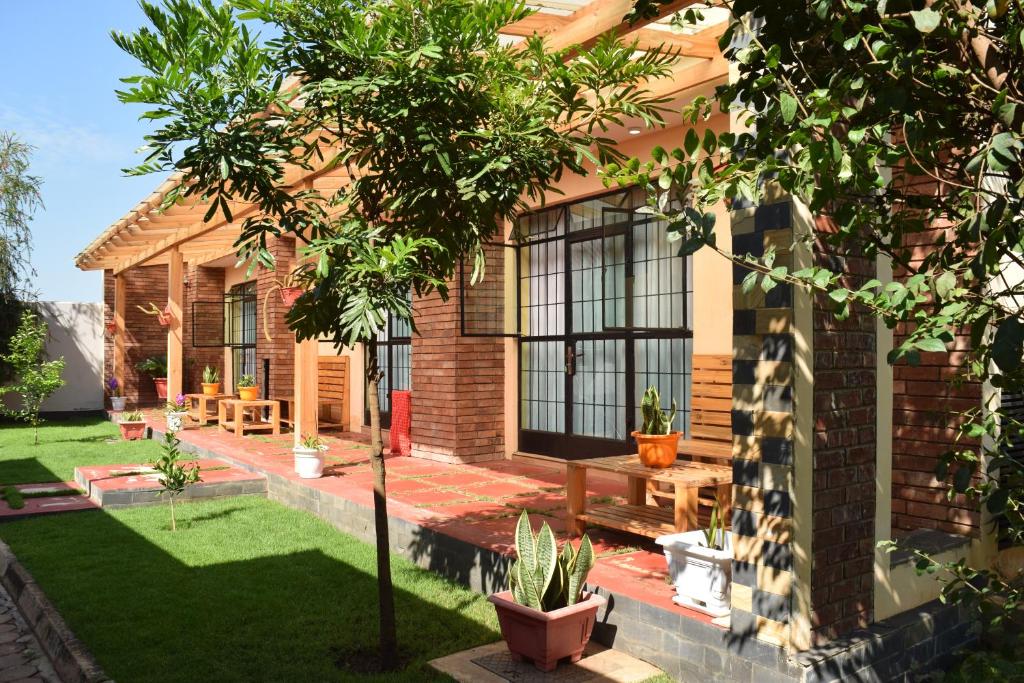 une maison avec un jardin et un arbre dans la cour dans l'établissement Tongas place, à Arusha